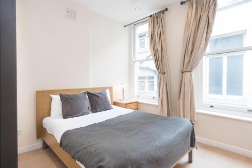 a bedroom with a bed and a large window at St Paul's by Excel Apartments in London