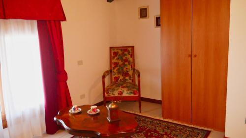 a living room with a chair and a table at hotel Vajont in Vaiont