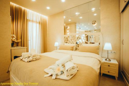 een slaapkamer met een groot bed met handdoeken erop bij Apartment Natalia Sea Towers in Batoemi