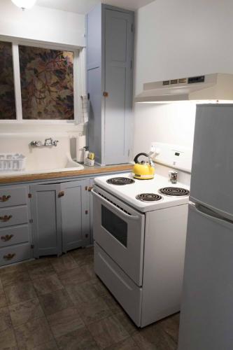 a kitchen with a white stove and a white refrigerator at Sauerdough Lodging in Seward