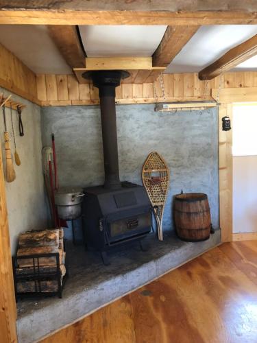 an old wood stove in a room with a wooden floor at Vines and Puppies Hideaway in Jade City
