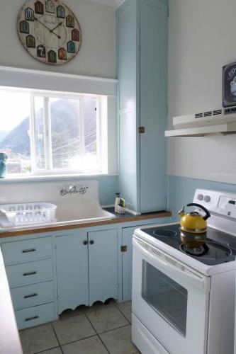 a white kitchen with a stove and a sink at Sauerdough Lodging in Seward
