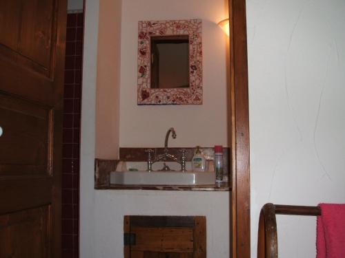 baño con lavabo y espejo en la pared en Chambres d'hôtes Sous L'Olivier, en Trausse