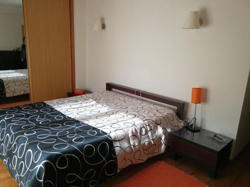 a bedroom with a bed and a table with a lamp at Casa Ofir in Esposende