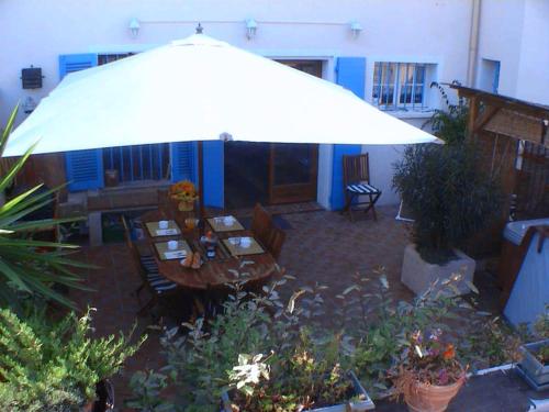 une terrasse avec une table et un parasol dans l'établissement Les Chambres de Solliès, à Solliès-Pont