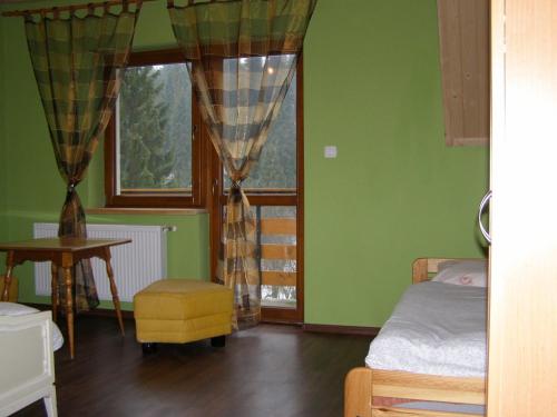 1 dormitorio con paredes verdes, 1 cama y ventana en Dom Gościnny Na Skolach, en Gliczarów Górny