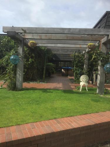 a pergola with a chair in a yard at Dons Place in Waikawa