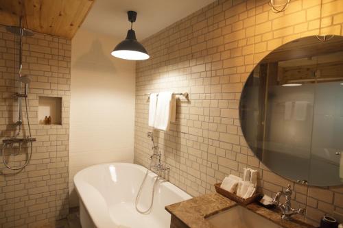 a bathroom with a tub and a sink and a mirror at Sanae' Townhouse Chiang Mai in Chiang Mai