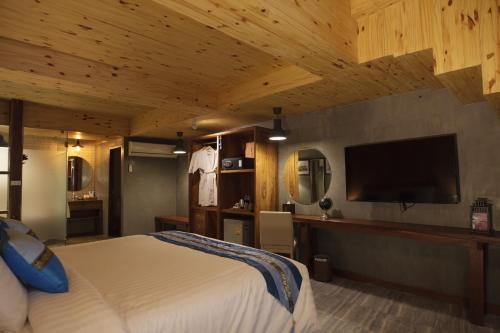 a bedroom with a bed and a flat screen tv at Sanae' Townhouse Chiang Mai in Chiang Mai