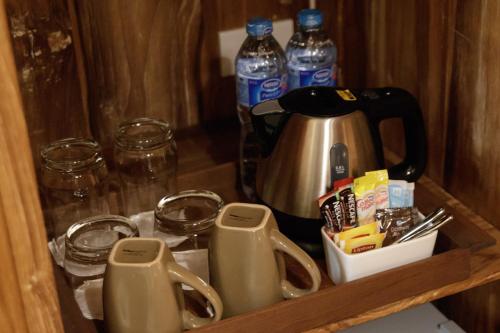 a cupboard with a tea kettle and bottles of water at Sanae' Townhouse Chiang Mai in Chiang Mai