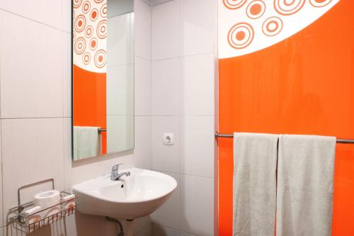 an orange and white bathroom with a sink and mirror at Grand Sinar Indah in Legian