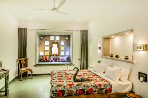 a hotel room with a bed and a window at The Neem Tree in Udaipur