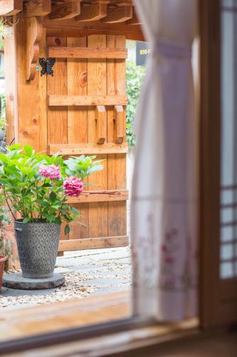 a vase with flowers in it next to a wooden wall at Starlight Rest Area in Jeonju