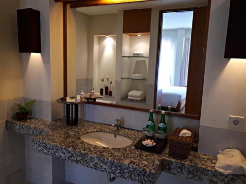 a bathroom with a sink and a large mirror at Billiton Hotel in Tanjungpandan