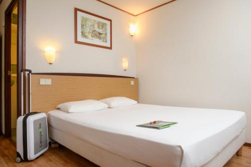 ein Hotelzimmer mit einem Bett mit einem Buch darauf in der Unterkunft Campanile Hotel & Restaurant Venlo in Venlo