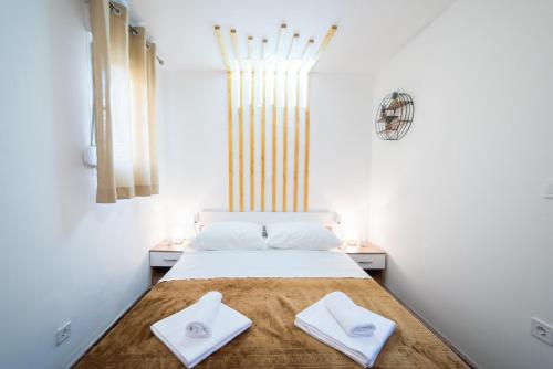 a bedroom with a bed with two white towels on it at Saint Blaise Apartment in Dubrovnik