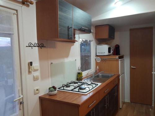a kitchen with a sink and a stove top oven at Lous Roussels in Le Bosc