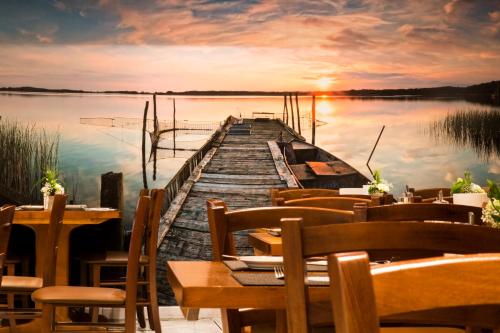 a dock on a lake with a sunset at Hotel Löwen in Meckenbeuren