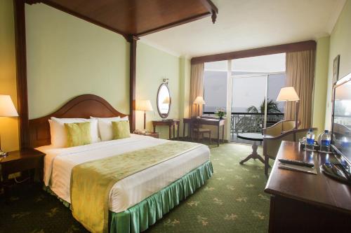 a hotel room with a large bed and a desk at Mount Lavinia Hotel in Mount Lavinia