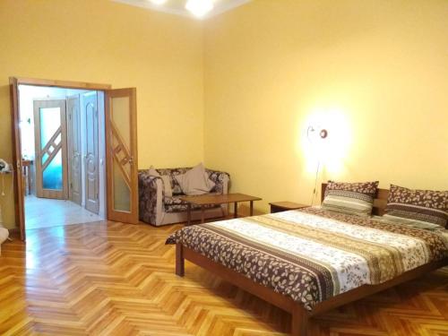 1 dormitorio con 1 cama y 1 silla en Apartment on Virmens'ka Street, en Leópolis