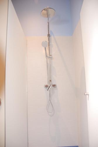 a shower in a white room with a shower at Albergue Xabarín in Abadín