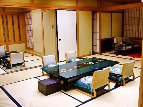 a dining room with a table and chairs at Asanoya in Shinonsen