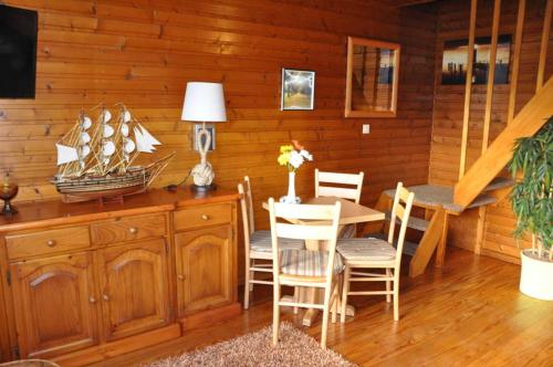 弗里德里希斯科格的住宿－Deichoase Piratenhaus，一间带桌子和木墙的用餐室