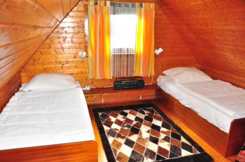 Habitación de madera con 2 camas y ventana en Deichoase Piratenhaus, en Friedrichskoog