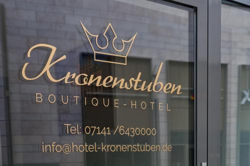 a sign for a hotel with a crown on a window at Boutique-Hotel Kronenstuben in Ludwigsburg