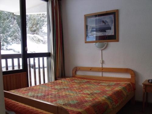 1 dormitorio con 1 cama en una habitación con ventana en Appartement Val Cristal, en Font-Romeu