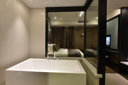 a bathroom with a white sink and a bedroom at SHANGHAI-DECO Hotel-Free shuttle bus to Pudong Airport and Disneyland in Shanghai