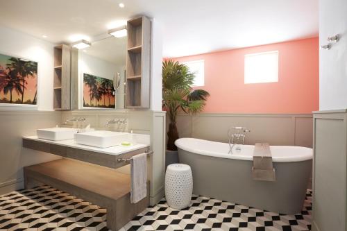 a bathroom with two sinks and a bath tub at LUX* Grand Gaube Resort & Villas in Grand Gaube