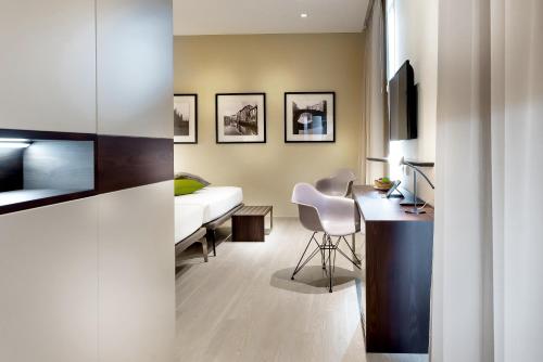a bedroom with a bed and a desk with a chair at Hotel Canada in Milan