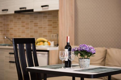 a table with a bottle of wine and two glasses at ANTARES Apart hotel in Lviv