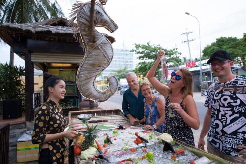 a group of people standing around a table with a fish sculpture at Seahorse Resort & Spa in Mui Ne