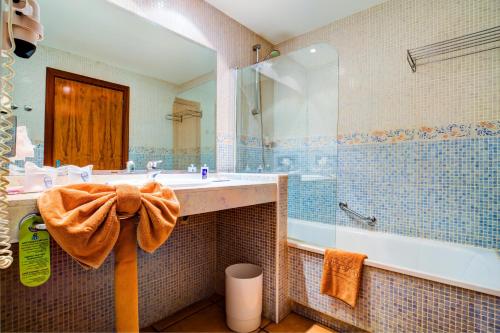 a bathroom with a tub and a sink and a shower at SBH Club Paraiso Playa in Playa Jandia