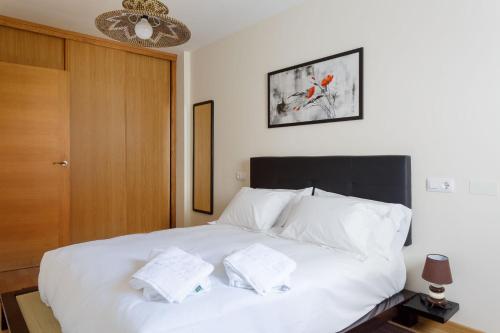 マルピカにある2- Apartamento Playa Canidoのベッドルーム1室(白いベッド1台、タオル2枚付)