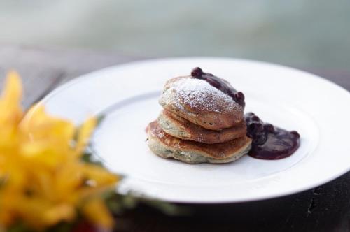 a white plate with a stack of pancakes and berries at Rocky's Boutique Resort - Veranda Collection Samui in Lamai