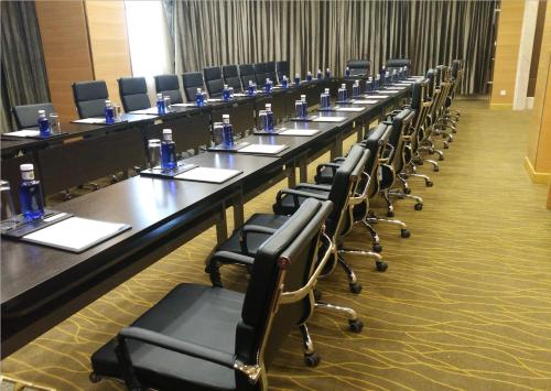 a long row of tables and chairs in a room at Hotel Anda China Malabo in Malabo
