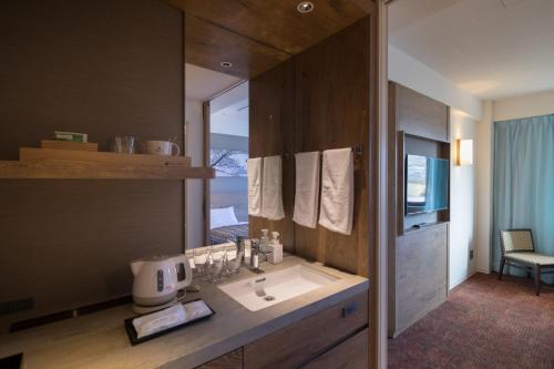 uma casa de banho com um lavatório e um espelho em Solest Takachiho Hotel em Takachiho