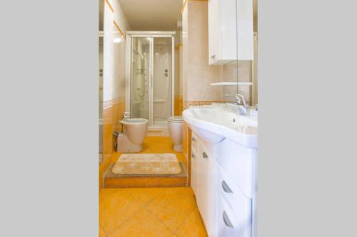 a bathroom with a white sink and a toilet at Bomboniera fronte mare ! in Viareggio