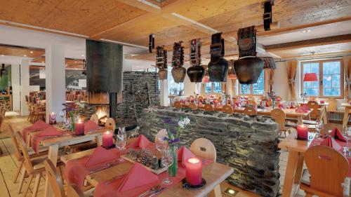 a restaurant with tables and chairs and a stone wall at Hotel Oberstdorf in Oberstdorf