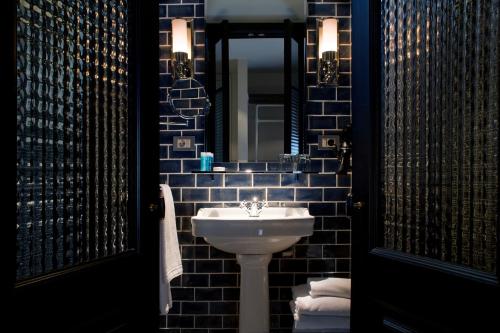 een badkamer met een witte wastafel en een spiegel bij Praktik Garden in Barcelona