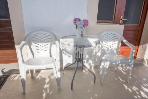 a table and two chairs and a vase with flowers on it at Villa Riva in Molunat