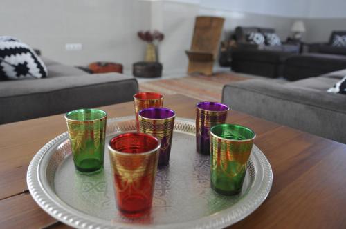 una bandeja con cuatro tazas de colores diferentes en una mesa en Hostal Tarifa, en Tarifa