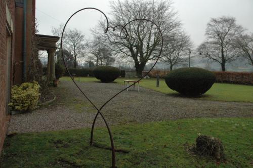 a metal sculpture in the grass next to a building at Mid Wales Arts B&B in Caersws