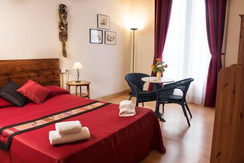 a bedroom with a red bed and a table with chairs at Fashion House in Barcelona