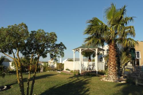 a house with a gazebo and a palm tree at Masada Guest House in Langebaan