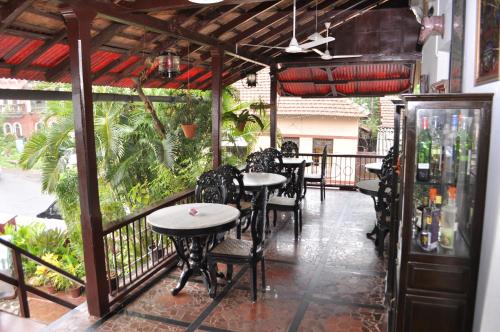 a patio with tables and chairs on a balcony at WelcomHeritage Panjim Inn in Panaji