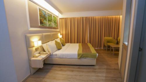 a hotel room with a bed and a table with a phone at Kingwood Hotel Kuching in Kuching